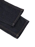 Close-up of dark wash women’s high-rise skinny jeans hem with contrast stitching