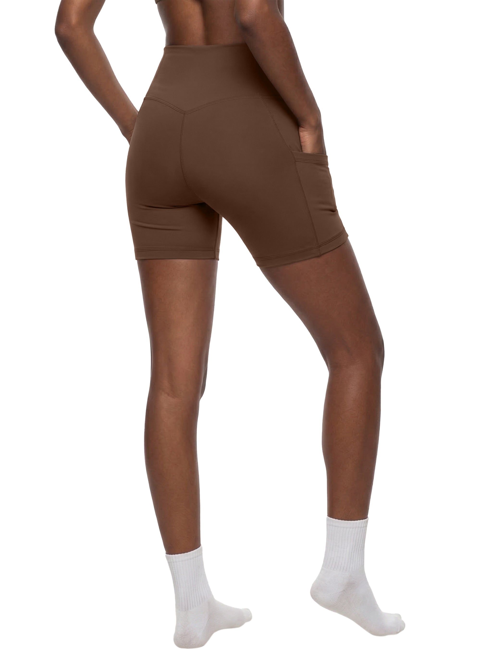 Woman modeling brown high-waisted biker shorts with pockets, shown from the back