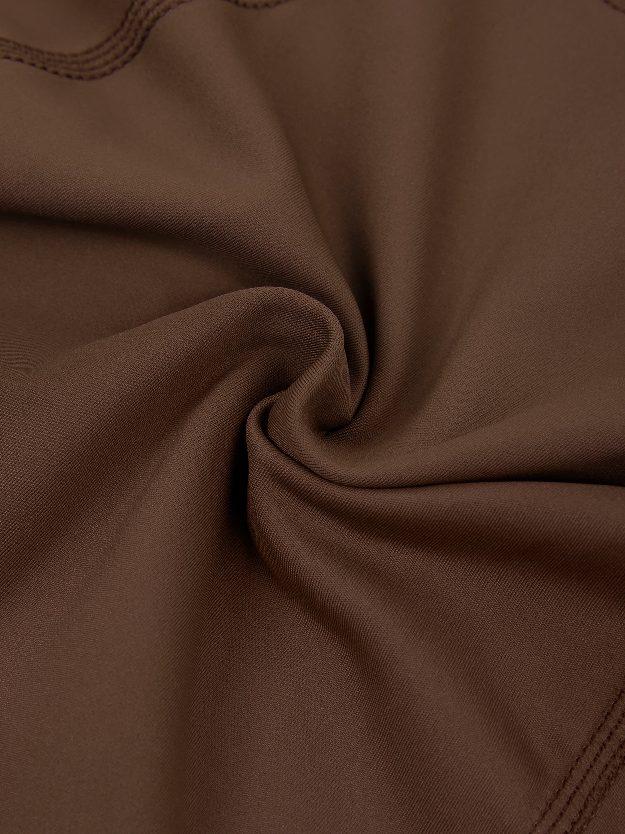 Close-up of stretchy brown athletic fabric with visible stitching detail