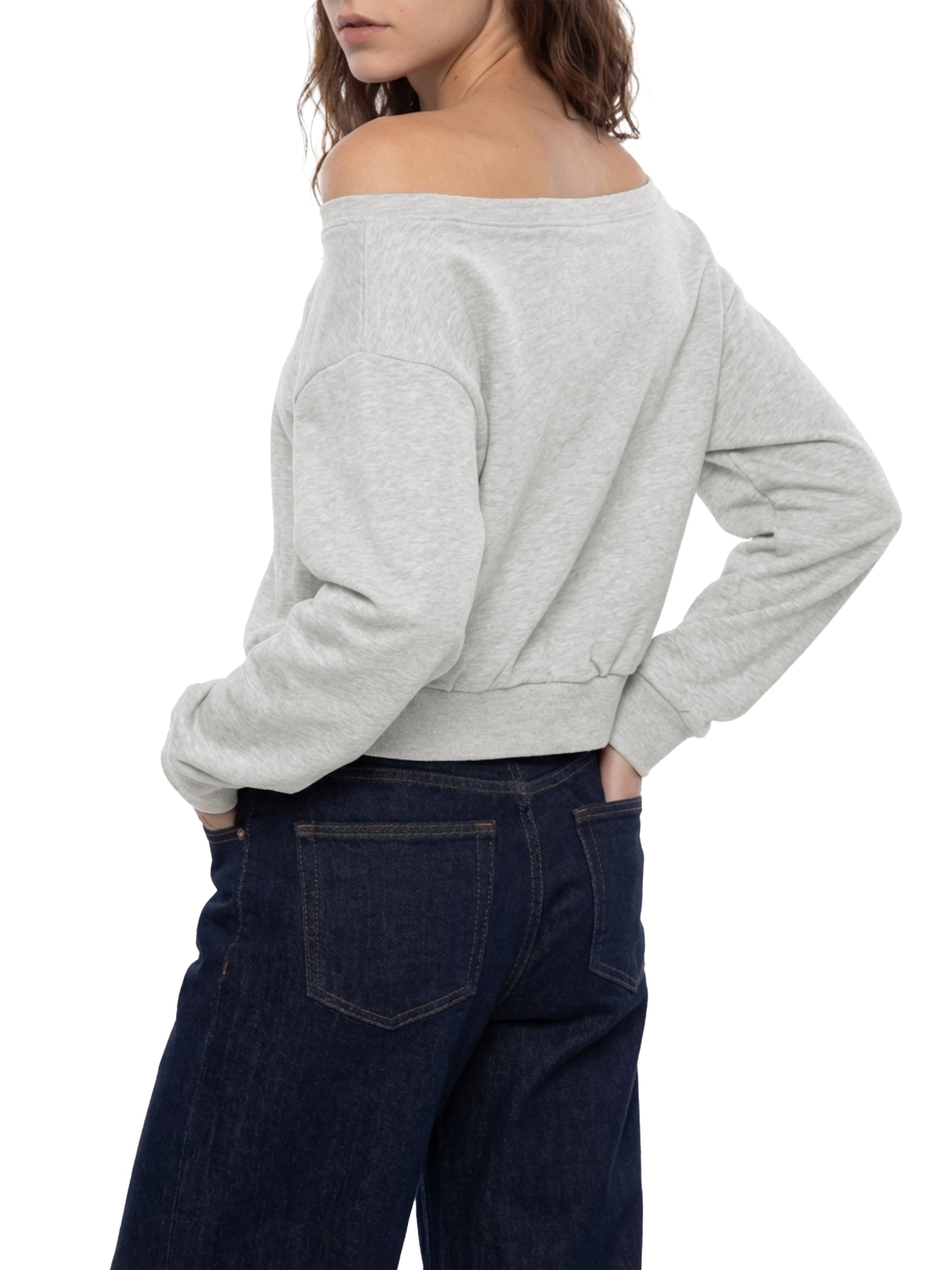 Woman in light gray off-shoulder sweatshirt and dark blue jeans, rear view