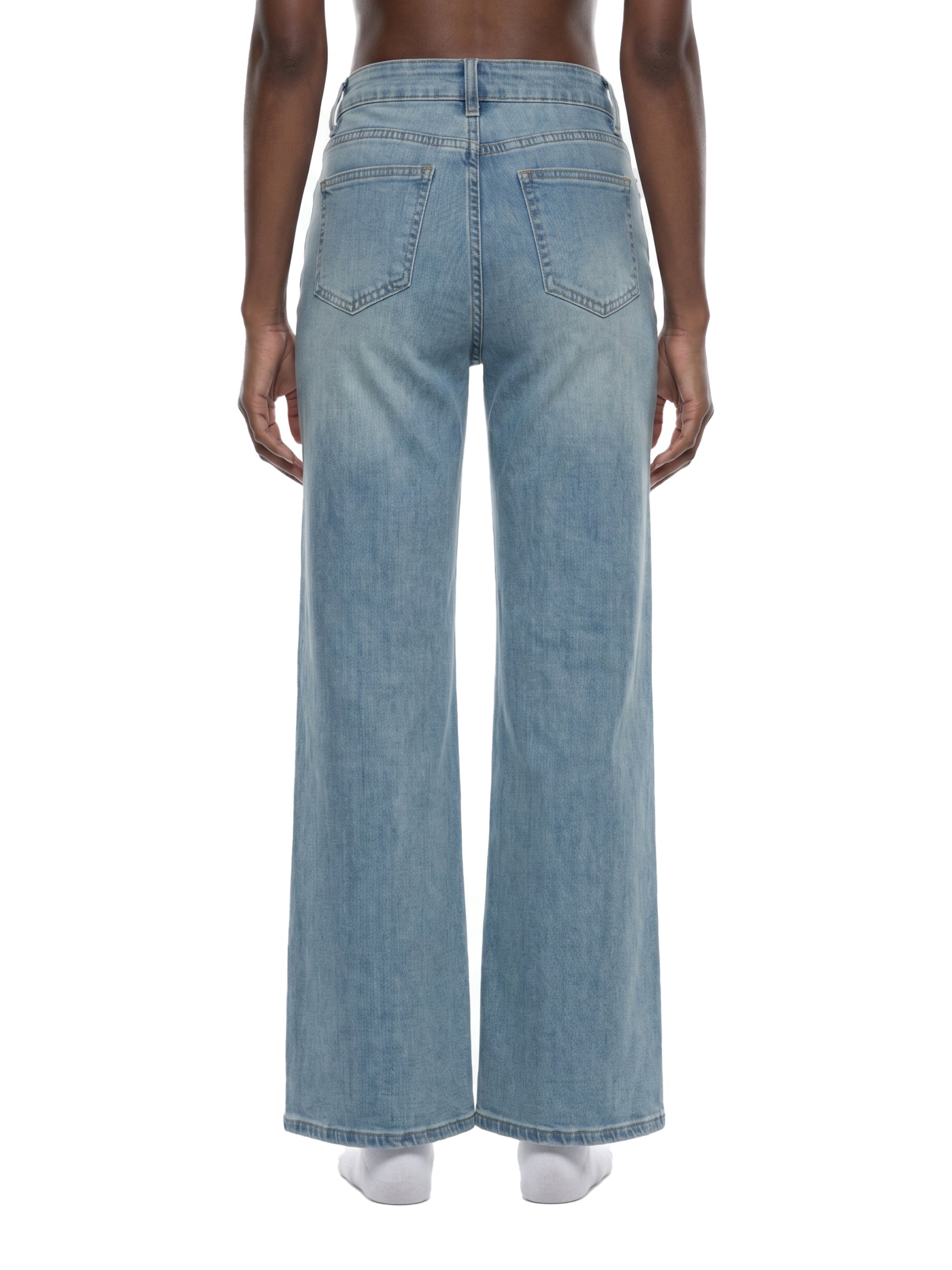 Back view of women's vintage wash flared leg jeans in light blue denim