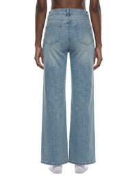 Back view of women's vintage wash flared leg jeans in light blue denim