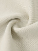 Close-up of beige denim fabric with visible texture and weave details.