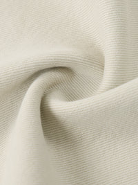 Close-up of beige denim fabric with visible texture and weave details.