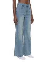 Women's vintage wash flared leg jeans in light blue denim, modeled on white background