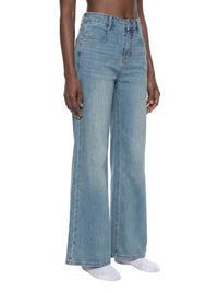 Women's vintage wash flared leg jeans in light blue denim, modeled on white background