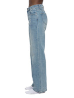 Women's vintage wash flared leg jeans in light blue denim, side profile view.