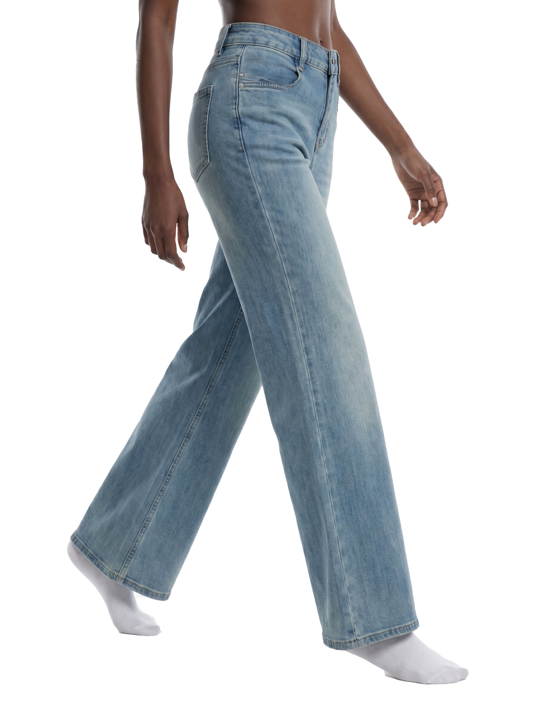 Woman wearing light wash flared leg jeans, side view, on white background