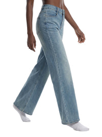 Woman wearing light wash flared leg jeans, side view, on white background