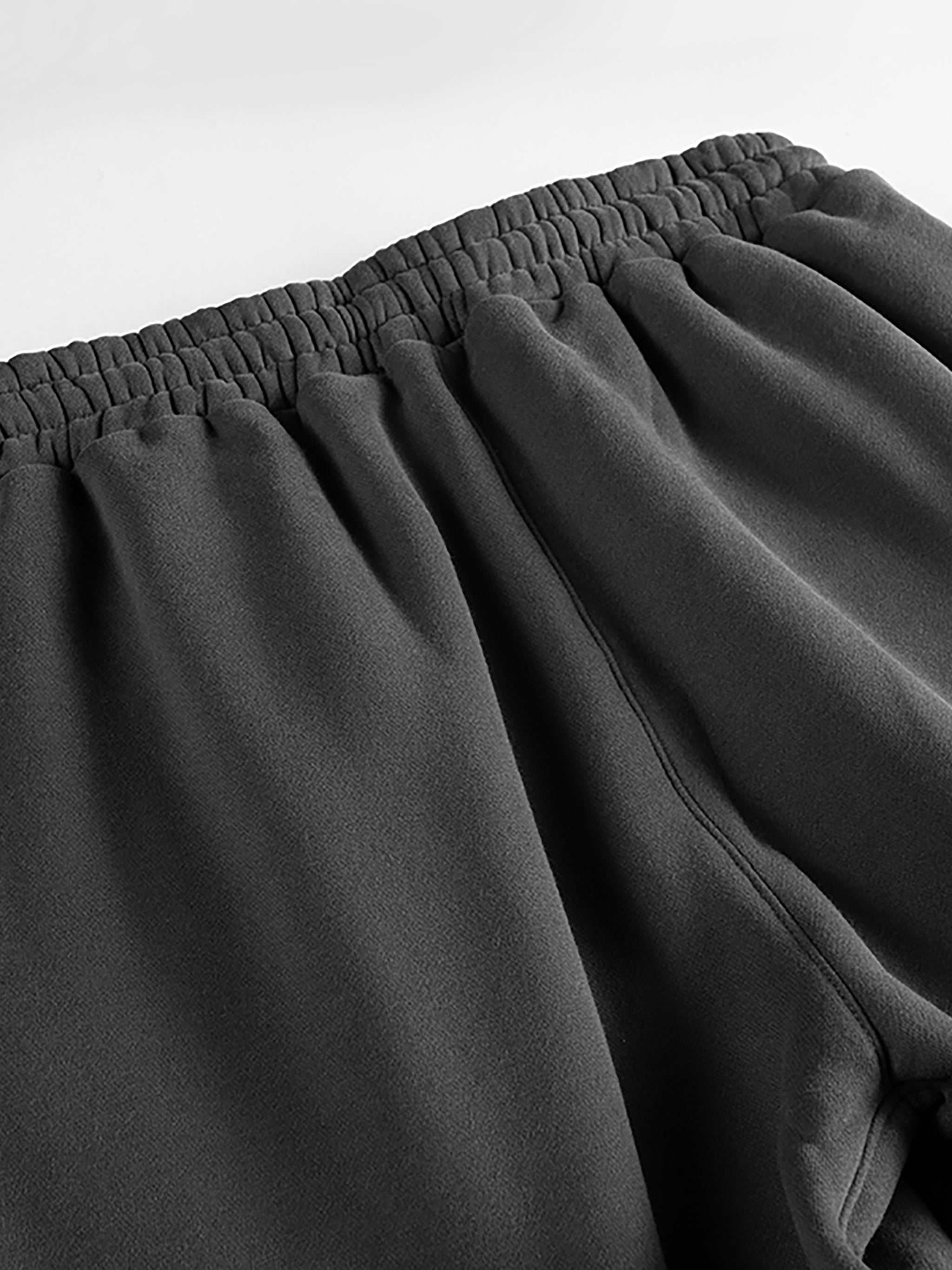 Close-up of heavyweight fleece unisex joggers with elastic waistband in dark gray