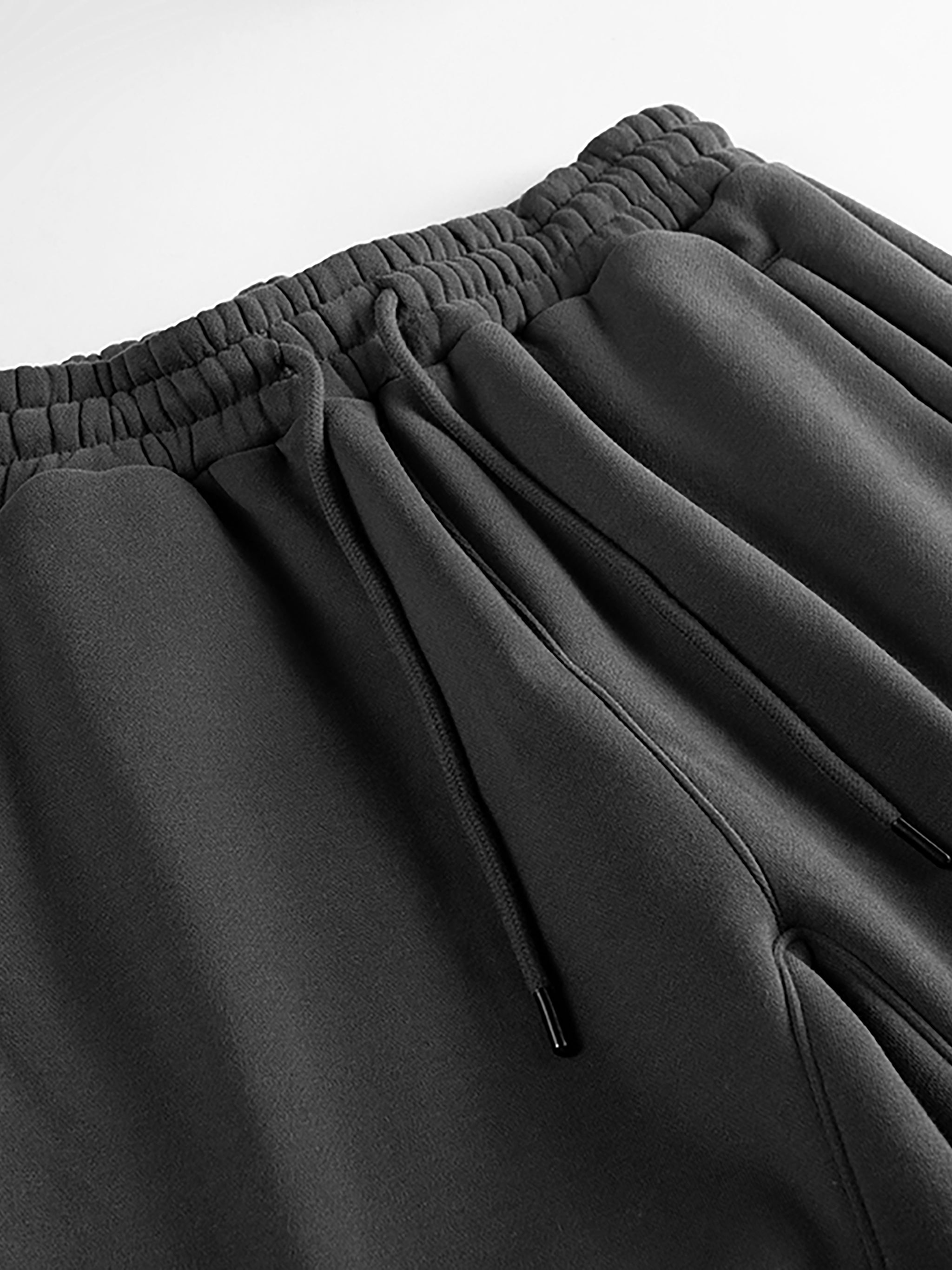 Close-up of black heavyweight fleece joggers with elastic waistband and drawstrings