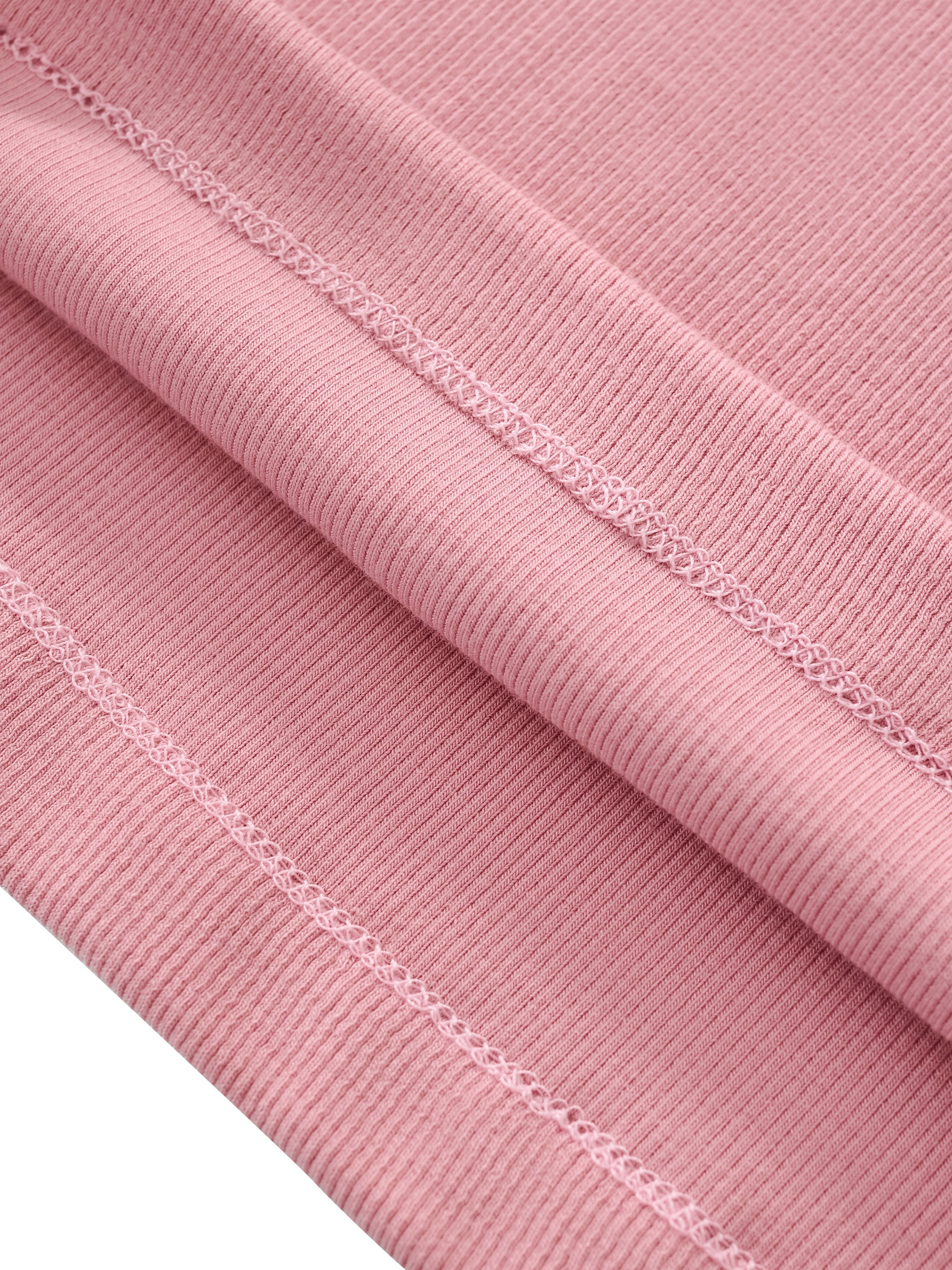 Close-up of pink ribbed slim fit mock neck t-shirt fabric with visible stitching