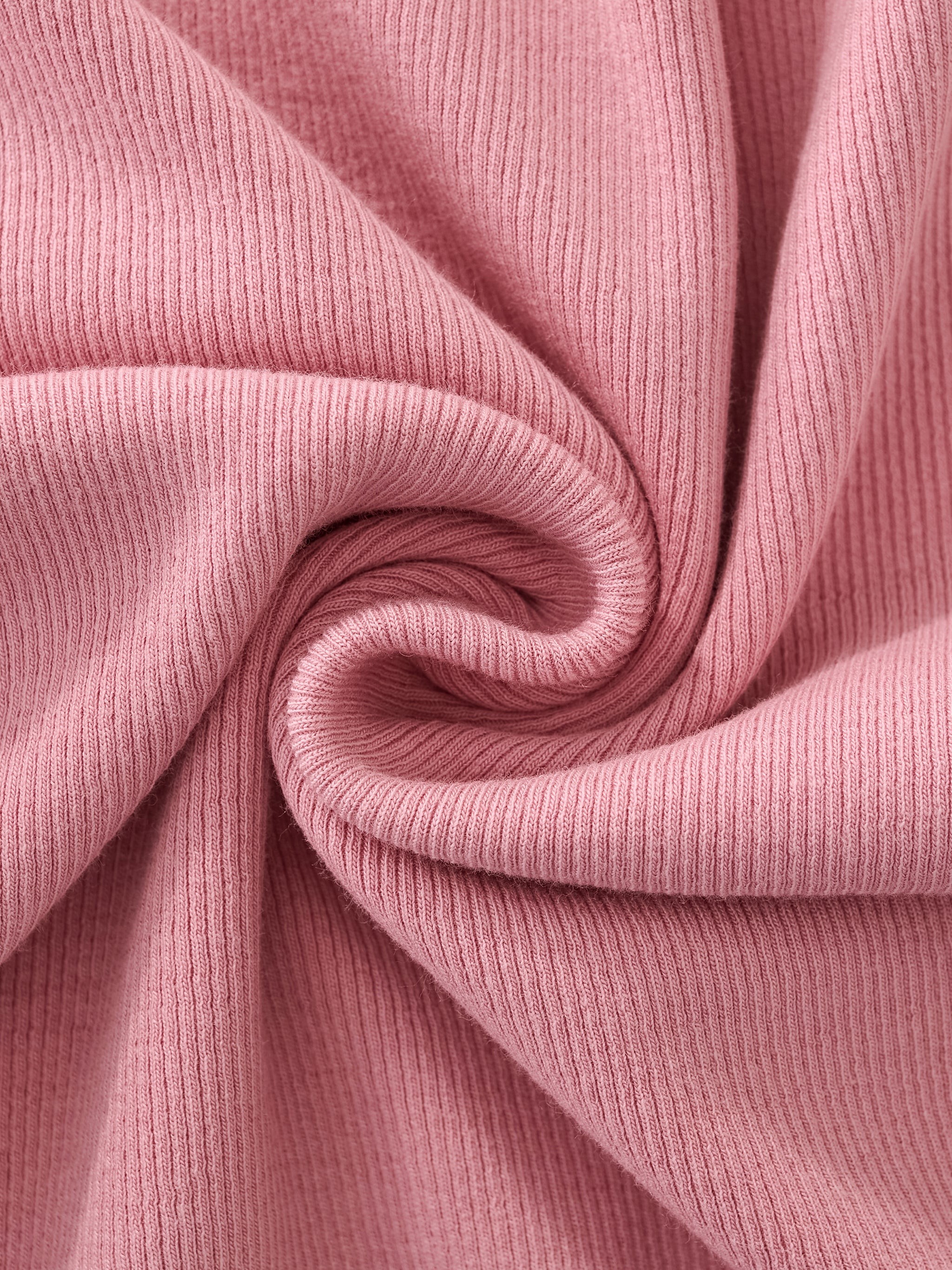Close-up of pink ribbed knit fabric, soft heavyweight texture, twisted for detail