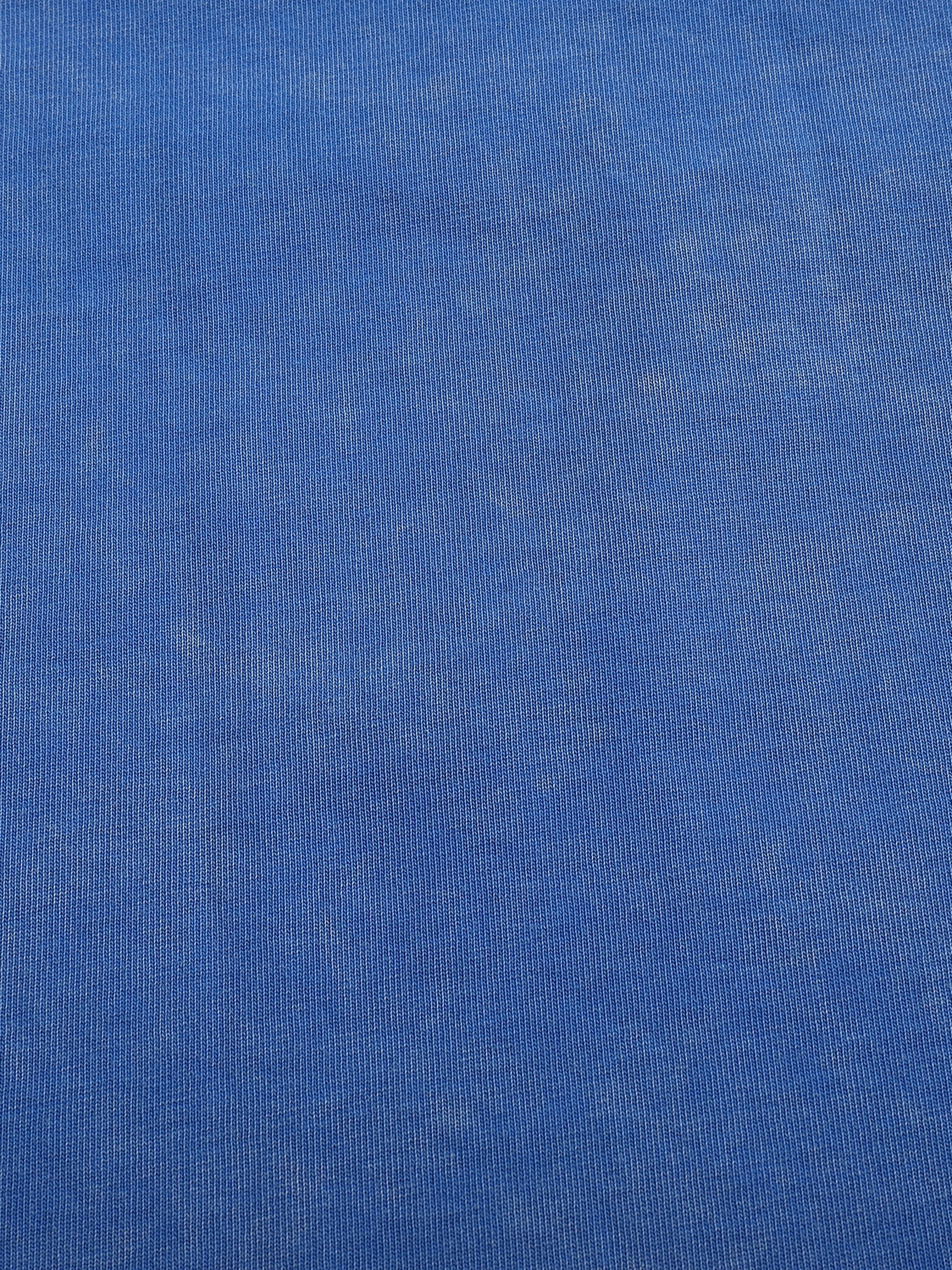 Close-up of snow washed blue cotton t-shirt fabric with subtle textured details