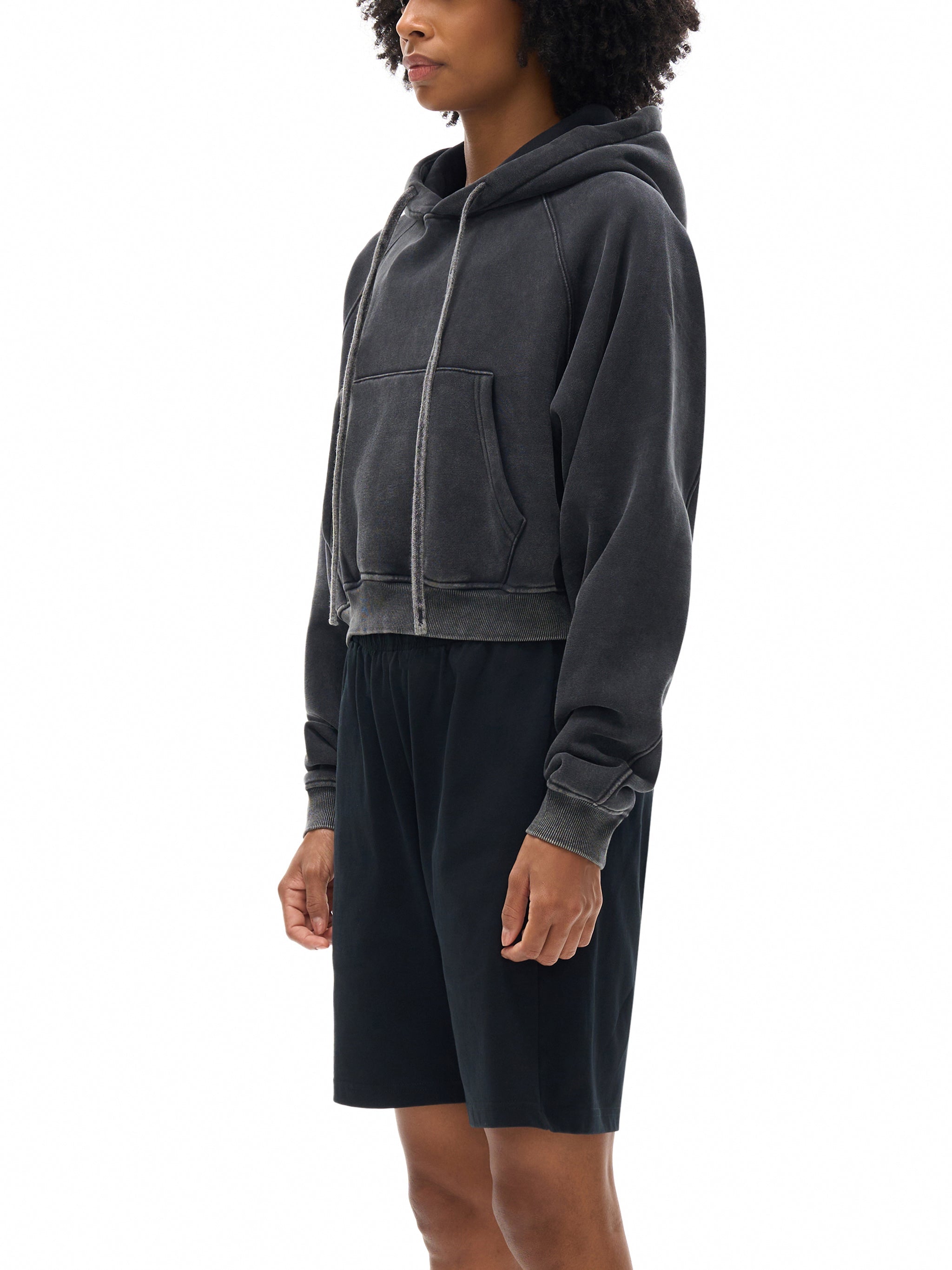 Snow washed cropped hoodie with kangaroo pocket and drawstring hood, modeled side view