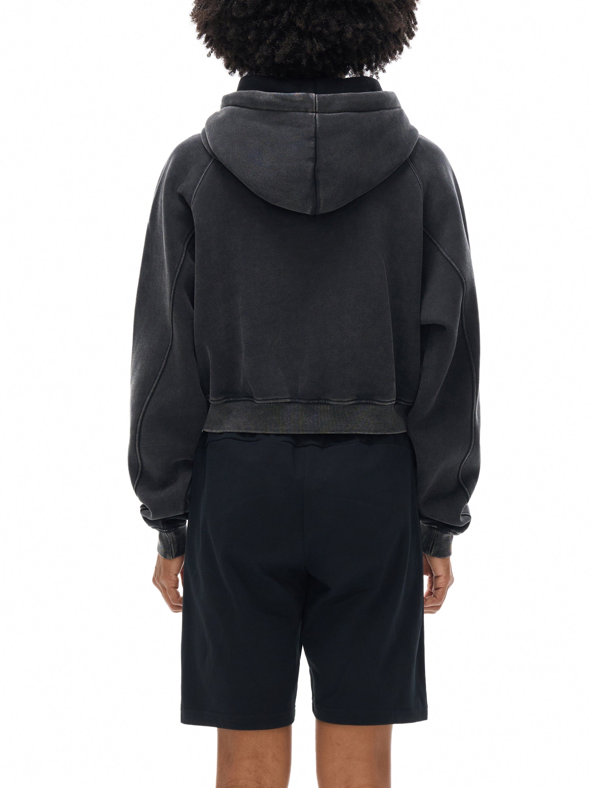 Back view of person wearing a snow washed cropped hoodie and black shorts