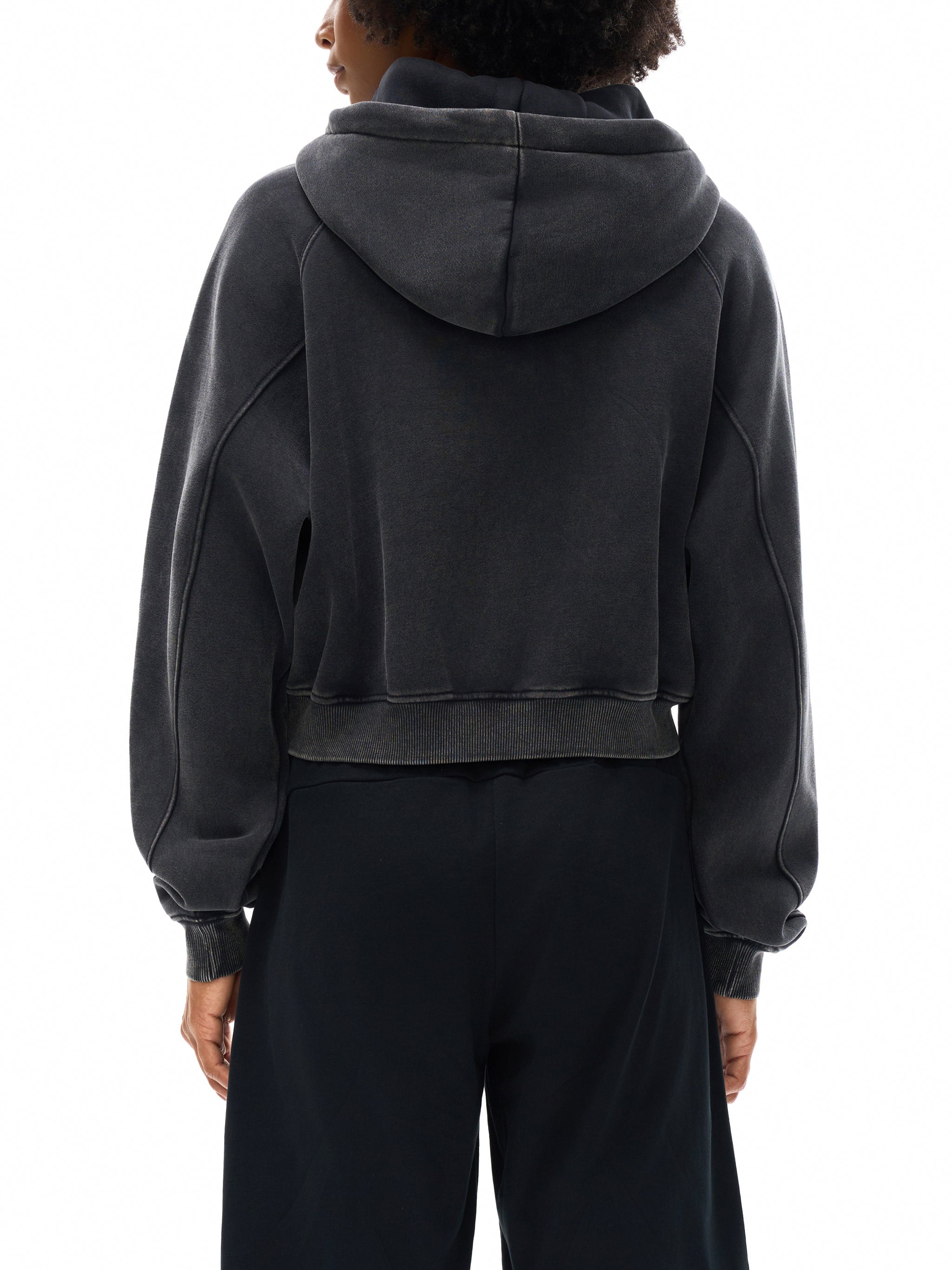 Back view of a person wearing a snow washed cropped hoodie with loose sleeves