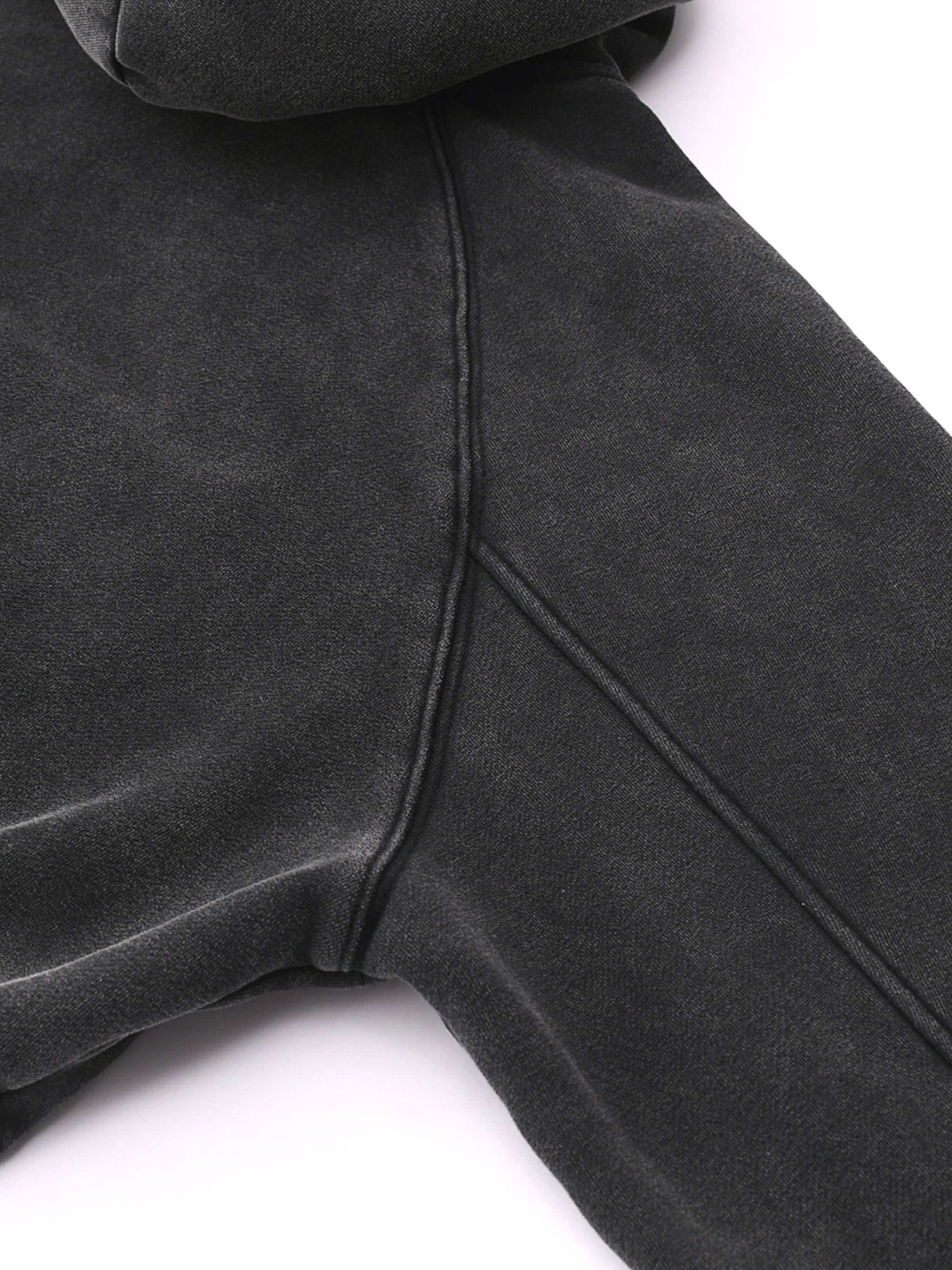 Close-up of snow washed cropped hoodie in dark grey heavyweight fabric showing stitching detail
