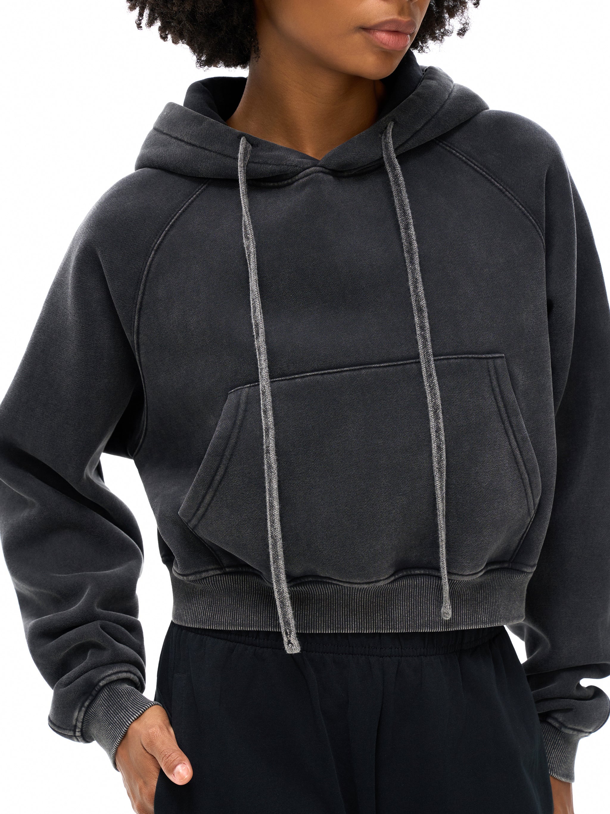 Snow washed cropped hoodie with drawstrings and kangaroo pocket, modeled on a person