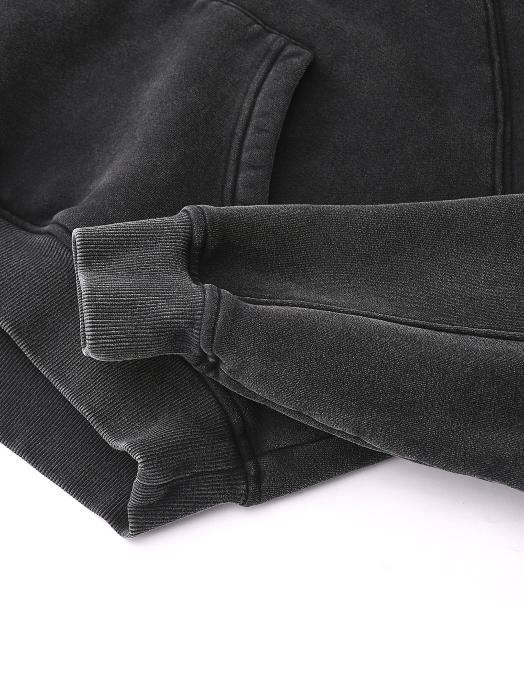 Close-up of black snow-washed cropped hoodie with ribbed cuffs and kangaroo pocket