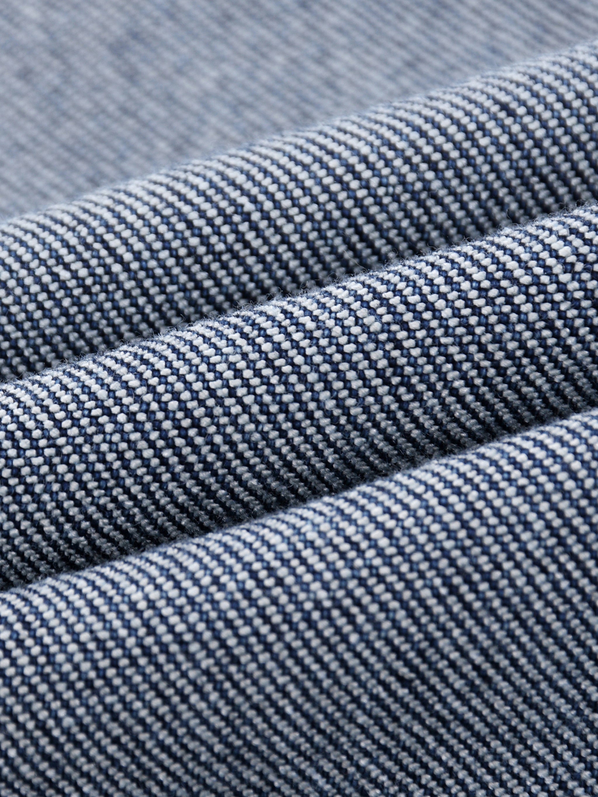 Close-up of heavyweight denim jeans fabric with textured sun-fade pattern