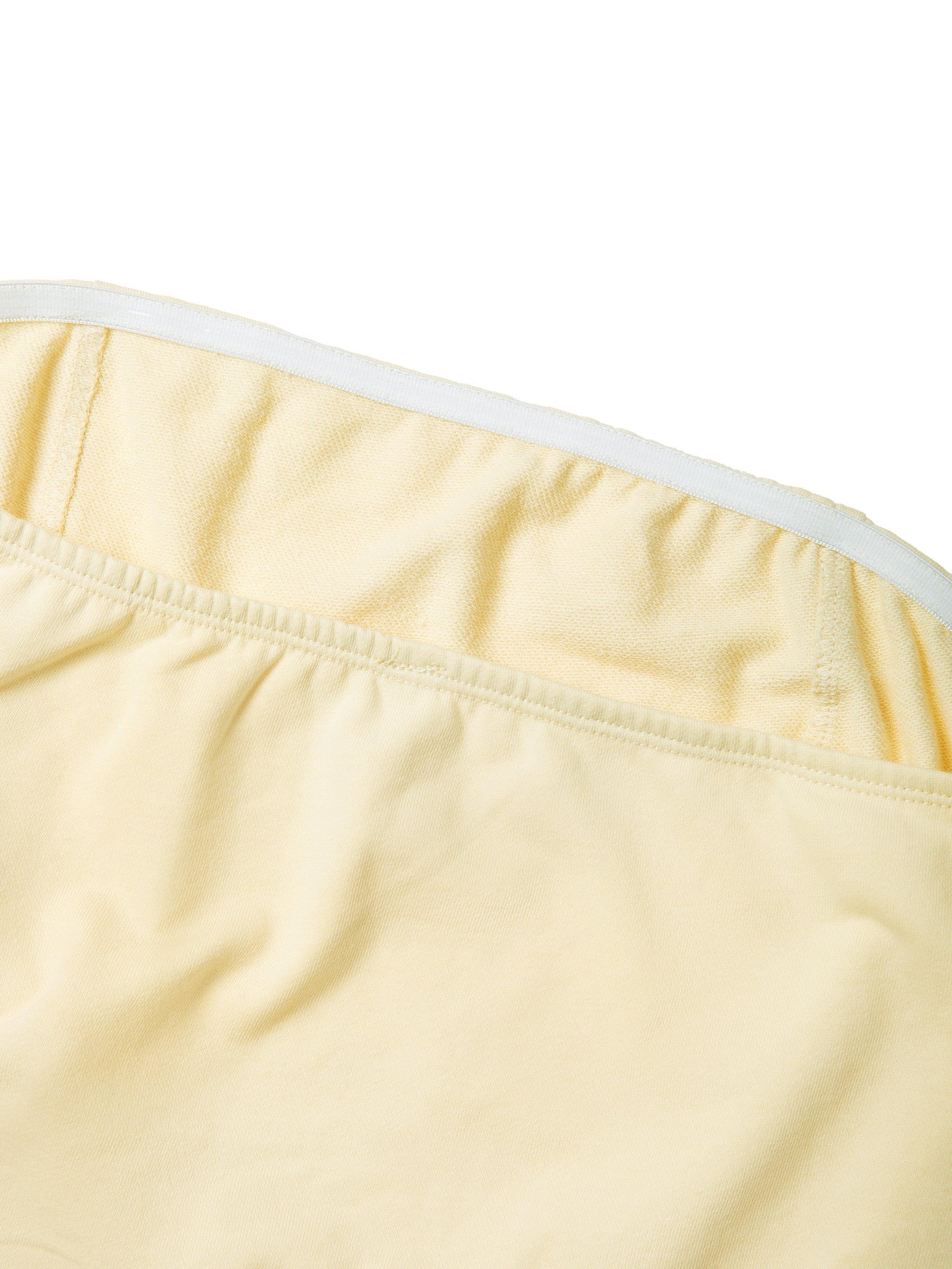 Close-up of yellow women's cropped tube top with elastic band and soft fabric texture