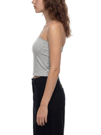 Side view of woman wearing a light grey cropped tube top and black high-waist pants